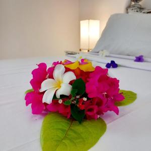 een boeket bloemen op een bed bij Lalasalama B&B in Watamu