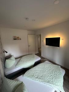 a bedroom with two beds and a flat screen tv at HT Appartement No.3 in Greppin