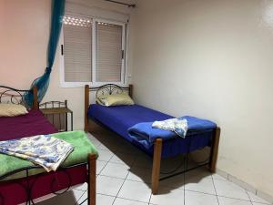 Cette chambre comprend 2 lits jumeaux et une fenêtre. dans l'établissement Appartement Marhaba, à Agadir