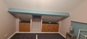 a kitchen with a blue ceiling and wooden cabinets at Charming 1-Bed Apartment in Barnsley in Barnsley