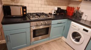 a kitchen with a stove top oven next to a washing machine at Charming 1-Bed Apartment in Barnsley in Barnsley