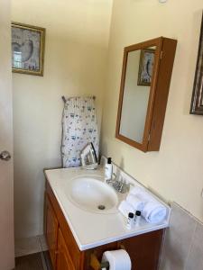 a bathroom with a sink and a chair at Cool Breeze Mobay in Montego Bay