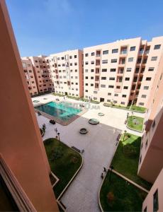een uitzicht op een groot appartementencomplex met een zwembad bij Appartement Deux chambres résidence Privée in Marrakesh