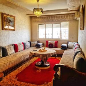 een woonkamer met een bank en een tafel bij Appartement Deux chambres résidence Privée in Marrakesh