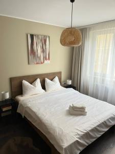 1 dormitorio con 1 cama blanca grande y 2 toallas en Igla House, en Baia Mare
