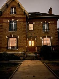 una vecchia casa di mattoni con porta d'ingresso e scale di Chambres cosy dans une maison meulière de charme a Saint-Maur-des-Fossés