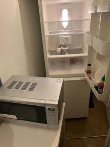 an open refrigerator with a microwave inside of it at Wilmot Close in London
