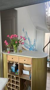 a table with a vase of pink flowers on it at Hôtel Eden - La Baigneuse in Juan-les-Pins