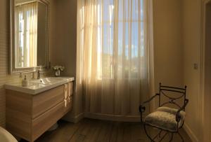 La salle de bains est pourvue d'un lavabo, d'un miroir et d'une fenêtre. dans l'établissement La Demeure d'Agapanthe, à Vinay