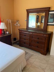 a bedroom with a dresser with a mirror on it at Cool Breeze Mobay in Montego Bay