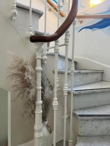 uma escada em espiral com uma pena ao lado em Hôtel Eden - La Baigneuse em Juan-les-Pins