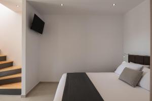 1 dormitorio con 1 cama y TV en la pared en Diva Lodge, en Sikia