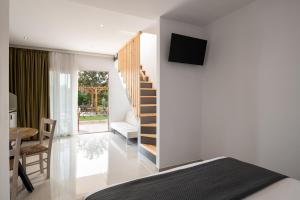 1 dormitorio con 1 cama, escalera y mesa en Diva Lodge, en Sikia
