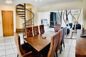 a dining room with a wooden table and chairs at 3 Bedrooms Maisonette in Patra