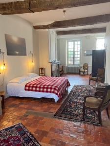 Un dormitorio con una cama y una mesa y sillas. en QUELQUES JOURS À NOYERS SUR SEREIN, en Noyers-sur-Serein