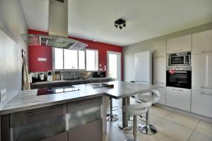 a kitchen with a large counter with stools in it at Sweet home 25mn du Puy du Fou in Cholet