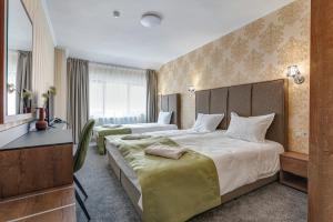 ein Hotelzimmer mit zwei Betten und einem Fernseher in der Unterkunft Къща за гости Чудните Мостове in Zabŭrdo + 26 Fotos