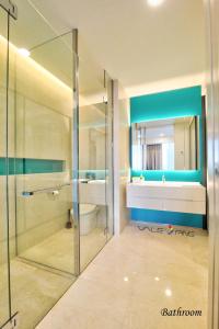 a bathroom with a glass shower and a sink at Tropicana The Residences KLCC By Luxury Suites in Kuala Lumpur