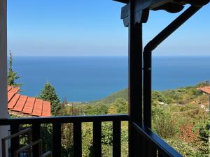 uitzicht op de bergen vanaf het balkon van een huis bij Melofegaro Guesthouse in Palaios Panteleimon