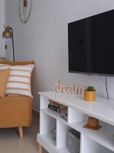a living room with a tv on a white entertainment center at L’angolo d’aMare in Lerici