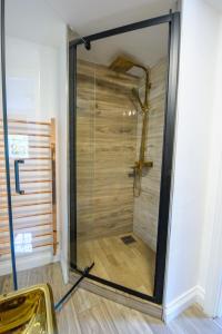 a shower with a glass door in a room at King Suite In 600 Year Old Manor House In Saffron Walden North Essex in Saffron Walden