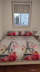 a bed with red roses and the eiffel tower at Apartmani Elix in Banja Luka