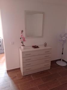a bedroom with a dresser with a mirror and a fan at Mar y reina in Puerto del Rosario