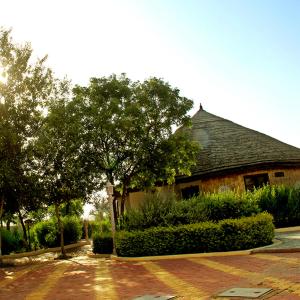 una casa con un árbol y una entrada de ladrillo en Neelkanth's Bagar Inn Resort, en Jhunjhunūn