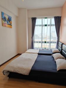 1 cama grande en un dormitorio con ventana en Homestay Melaka Mahkota Melaya Raya en Melaka