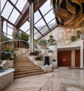 a lobby with stairs and a large glass ceiling at Mirage Hotel & Conference Center in Alexandria