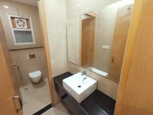 a bathroom with a white sink and a toilet at Hotel Royal Casa in Lucknow