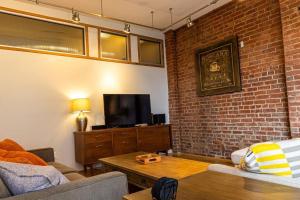 a living room with a couch and a brick wall at Roanoke Roofdeck Loft. Central Downtown Location. in Roanoke