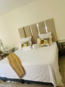a bedroom with a large bed with white sheets and pillows at Kalaji C-Rane Lodge in Phalaborwa