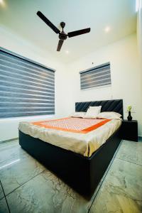 1 dormitorio con 1 cama y ventilador de techo en Shams al Imarat, en Palakkad