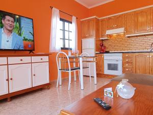 a kitchen with a tv and a table in a room at CASA LA MOLINA in Triquivijate