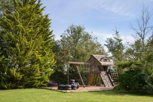 a playground in a yard with a play house at Lux 2 Bed Versace Bungalow Hot Tub, Sky TV, Cinema Screen Saffron Walden in Saffron Walden