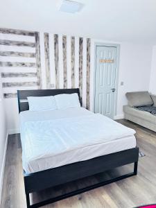 1 dormitorio con 1 cama y 1 sofá en Self-contained Annex for short stay, en Bushey