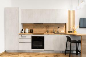 a kitchen with white cabinets and a black dishwasher at Studio in the heart of Cluj in Cluj-Napoca