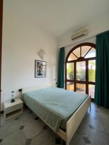 - une chambre avec un lit et une grande fenêtre dans l'établissement Residence Pian Dei Boschi, à Pietra Ligure