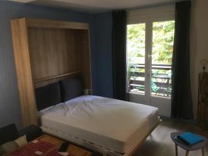 a bedroom with a white bed and a window at Lo Cantalés d’Aubrac in Laguiole