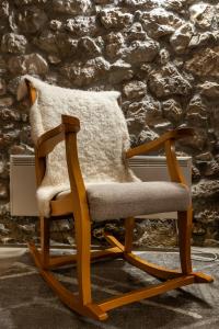 a wooden rocking chair with a pillow on it at Stone room-Kamena soba in Šipovo