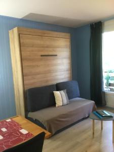 - une chambre avec un lit et une tête de lit en bois dans l'établissement Lo Cantalés d’Aubrac, à Laguiole