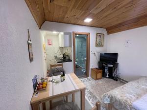 a living room with a table and a room with a bed at Small house Floki in Žabljak