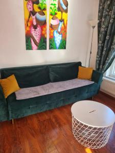 ハノーファーにあるTop Apartment in Langenhagenのリビングルーム(緑のソファ、テーブル付)