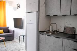 a kitchen with a white refrigerator and a couch at Lima Residence in Nicosia