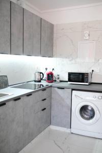 a kitchen with a washing machine and a microwave at Lima Residence in Nicosia