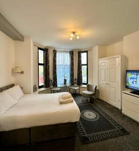 1 dormitorio con 1 cama grande y TV en The Carlton's Holiday Suites, en Bridlington