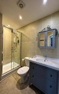 a bathroom with a toilet and a shower and a sink at The Carlton's Holiday Suites in Bridlington