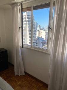 een slaapkamer met een raam met uitzicht op de stad bij Palermo Hollywood in Buenos Aires