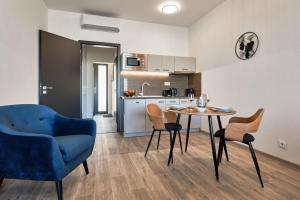 a living room with a table and chairs and a kitchen at RELAX PARK Třeboň II in Třeboň